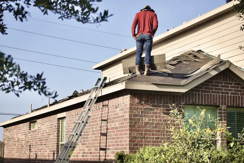 Professional roofer working on a residential roof in Tuscumbia